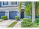Close-up of townhome with blue garage doors, inviting front door, and mature landscaping at 4528 Amberly Oaks Ct, Tampa, FL 33614