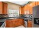 Kitchen area showcasing wood cabinets, tile backsplash, and stainless steel appliances at 4528 Amberly Oaks Ct, Tampa, FL 33614