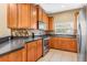 Kitchen with wood cabinets, black countertops, stainless steel appliances, and tile backsplash at 4528 Amberly Oaks Ct, Tampa, FL 33614