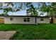 Backyard featuring a well-maintained lawn with view of the exterior of the house under a bright blue sky at 4624 83Rd Terrace N, Pinellas Park, FL 33781