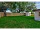 Spacious backyard with lush green grass, mature trees, wood fence, and a shed at 4624 83Rd Terrace N, Pinellas Park, FL 33781