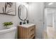 Bright bathroom features wood vanity with modern faucet, decorative mirror and light fixture, and neutral walls at 4624 83Rd Terrace N, Pinellas Park, FL 33781
