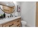 A stylish bathroom featuring a wood vanity, modern fixtures, and a sleek, round mirror at 4624 83Rd Terrace N, Pinellas Park, FL 33781