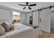Bright bedroom featuring barn doors, modern decor, and a ceiling fan for comfortable living at 4624 83Rd Terrace N, Pinellas Park, FL 33781