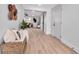 Bright hallway with light wood floors, a wicker bench, decorative wall hangings, and a view into the living room at 4624 83Rd Terrace N, Pinellas Park, FL 33781