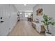 Hallway with light wood floors, wicker bench, views into dining and living areas, and plants at 4624 83Rd Terrace N, Pinellas Park, FL 33781