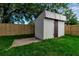 Close-up of the backyard storage shed surrounded by green grass and a wooden fence at 4624 83Rd Terrace N, Pinellas Park, FL 33781
