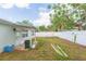 Side view of the backyard featuring a white privacy fence showing the lawn and the home's exterior at 4714 W Lawn Ave, Tampa, FL 33611