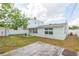 View of the backyard with a patio deck, a shed, and a partial view of a two story house beyond the privacy fence at 4714 W Lawn Ave, Tampa, FL 33611
