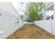 Side view of backyard featuring a white privacy fence with grass and a shed visible in the background at 4714 W Lawn Ave, Tampa, FL 33611