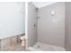 Shower featuring gray tile and glass shelf, with open walls at 4714 W Lawn Ave, Tampa, FL 33611