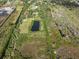 Aerial view of a spacious property featuring a serene pond, mature trees, and abundant green space at 4858 Troydale Rd, Tampa, FL 33615