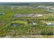 An aerial view showing multiple properties including a site with a pond, trees and green space for potential development at 4858 Troydale Rd, Tampa, FL 33615