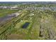 Expansive aerial view showcasing a large lot, a pond, and lush greenery, offering privacy and a natural setting at 4858 Troydale Rd, Tampa, FL 33615