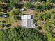 An aerial view showcases the home nestled within a lush, wooded lot, offering privacy and serene natural surroundings at 4858 Troydale Rd, Tampa, FL 33615