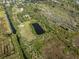 Aerial view of the property with a pond, surrounding marsh, and lush landscape at 4858 Troydale Rd, Tampa, FL 33615