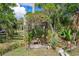 Landscaped yard with a charming vine-covered arbor, creating a serene and inviting outdoor space with bench seating at 4858 Troydale Rd, Tampa, FL 33615