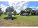Large backyard with mature trees and lush grass, showcasing a vintage RV and ample space for outdoor enjoyment at 4858 Troydale Rd, Tampa, FL 33615