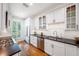 Bright kitchen featuring white cabinets, stainless steel appliances, black countertops, and subway tile backsplash at 5015 S Elberon St, Tampa, FL 33611