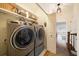 Laundry room featuring new machines, storage shelves, and a view to a hallway at 5015 S Elberon St, Tampa, FL 33611