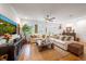Bright living room featuring hardwood floors, neutral sofas, and multiple windows for natural light at 5015 S Elberon St, Tampa, FL 33611