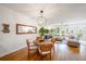 Bright living room featuring hardwood floors, a dining area, natural lighting, and neutral colored furnishings at 5015 S Elberon St, Tampa, FL 33611