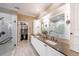 Luxurious bathroom with dual sinks, white cabinets, and a glass-enclosed shower and walk-in closet at 5015 S Elberon St, Tampa, FL 33611