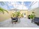 Relaxing screened patio features a dining set, outdoor grill, tiled flooring, and lush greenery, ideal for outdoor dining and entertaining at 5015 S Elberon St, Tampa, FL 33611