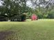 Expansive backyard with a red shed, offering ample space for outdoor activities and storage at 5173 Kirkland Ave, Spring Hill, FL 34606