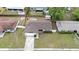 Aerial view of house with shingled roof, driveway, green grass, and surrounding neighborhood at 5213 Burr Pl, Seffner, FL 33584