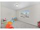 Bright, carpeted bedroom featuring a window, neutral walls, and a ceiling light at 5213 Burr Pl, Seffner, FL 33584