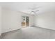 Airy bedroom with a ceiling fan, neutral walls, and sliding glass door to the backyard at 5213 Burr Pl, Seffner, FL 33584