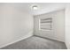 Cozy bedroom featuring neutral walls, gray carpeting, and a window at 5213 Burr Pl, Seffner, FL 33584