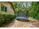 Backyard with a trampoline and lush greenery, providing a fun and private outdoor space at 5702 Ainsworth W Ct, Tampa, FL 33647