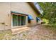 Back of house featuring blue awnings over sliding doors, and a stone tiled patio at 5702 Ainsworth W Ct, Tampa, FL 33647