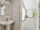 Bathroom featuring a pedestal sink in the foreground, leading to a bedroom with window seating at 5702 Ainsworth W Ct, Tampa, FL 33647