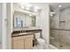 Well-lit bathroom featuring vanity, toilet, and glass door shower with tiled walls at 5702 Ainsworth W Ct, Tampa, FL 33647