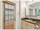 Bathroom with wood-slat door and vanity featuring solid surface counter top at 5702 Ainsworth W Ct, Tampa, FL 33647