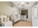 Cozy bedroom featuring a white crib, ceiling fan, and natural light from a window at 5702 Ainsworth W Ct, Tampa, FL 33647