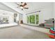 Multi-purpose bonus room with a window seat, carpet, and views into the adjacent living room with fireplace at 5702 Ainsworth W Ct, Tampa, FL 33647