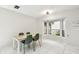 Bright dining room featuring a bay window, modern light fixture, and stylish green chairs around a light wood table at 5702 Ainsworth W Ct, Tampa, FL 33647