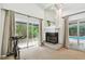 Bright living room with fireplace, sliding glass door to a pool, and plenty of natural light at 5702 Ainsworth W Ct, Tampa, FL 33647