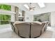 Living room with stone fireplace, vaulted ceilings, and large windows offering views of lush greenery at 5702 Ainsworth W Ct, Tampa, FL 33647