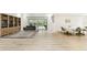 Bright and open living area with wood floors, a bookcase, and sliding glass doors to the patio at 5702 Ainsworth W Ct, Tampa, FL 33647