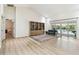 Inviting living room with vaulted ceilings, a bookcase, a sofa, and sliding glass doors to the pool area at 5702 Ainsworth W Ct, Tampa, FL 33647