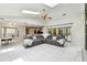 Open-concept living area featuring a stone fireplace, gray sectional, and sliding doors to the pool area at 5702 Ainsworth W Ct, Tampa, FL 33647
