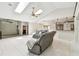 Open-concept living area with skylights, a ceiling fan, gray sectional, and seamless access to the kitchen at 5702 Ainsworth W Ct, Tampa, FL 33647