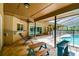 Covered lanai includes travertine tile, wet bar, lounge chair, and screened-in pool at 5702 Ainsworth W Ct, Tampa, FL 33647