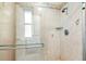 Shower with a glass door, window, tiled walls, and sleek fixtures, providing a spa-like experience at 5702 Ainsworth W Ct, Tampa, FL 33647