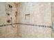 Shower featuring tiled walls with accent stripe, shower head and hardware at 5702 Ainsworth W Ct, Tampa, FL 33647